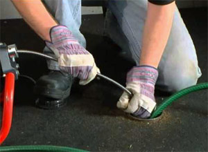 a tech is using the Rigid snake to clear a drain